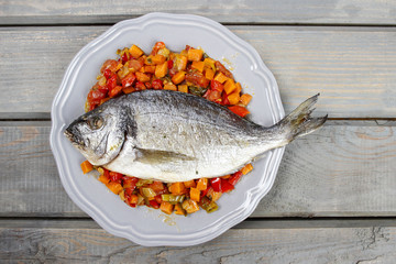 Top view of gilt-head bream fish on wooden background.