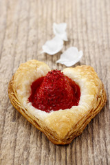 Puff pastry cookies in heart shape filled with strawberries.