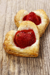 Puff pastry cookies in heart shape filled with strawberries.
