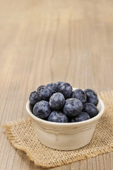 Bowl of blueberries on wooden table.