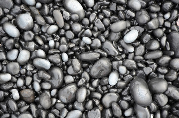 Black lava pebbles on beach