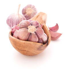 Garlic cloves in wooden bowl isolated on white background