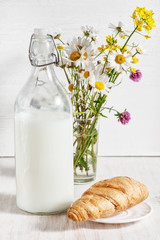 Fresh milk in old fashioned bottle with croissant