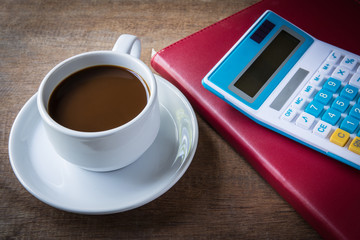 Fototapeta na wymiar Cup of coffee, books and calculator, on table wood
