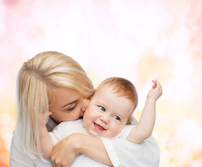 happy mother kissing smiling baby