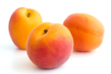 Fototapeta na wymiar Three beautiful ripe apricots arranged on white.