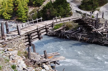 Tuinposter Wooden foot bridge over a glacial river, Himalayas, Nepal © Taylored Images