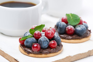 delicious mini cakes with chocolate cream and berries