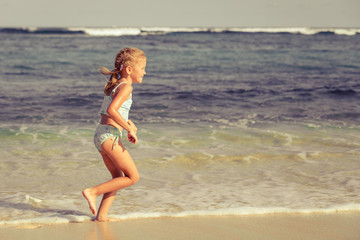 Fototapeta na wymiar little girl running on the beach