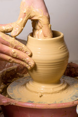 hands of a potter, creating an earthen jar