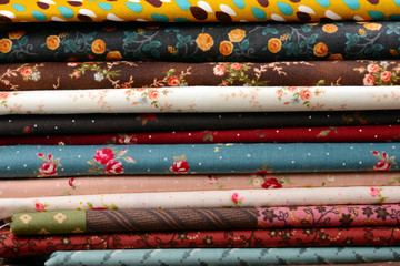 heap of cloth fabrics on wooden table