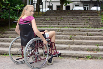 Frau mit Gehbehinderung vor Treppe als Hindernis
