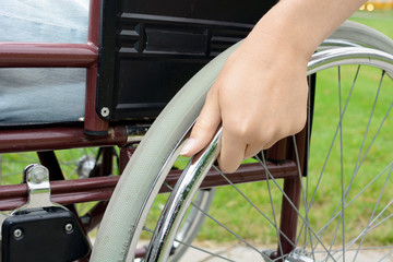 Hand an Rollstuhl in Nahaufnahme