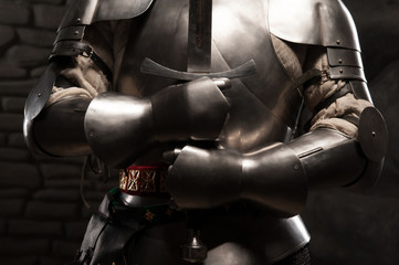 Fototapeta na wymiar Closeup portrait of medieval knight in armor holding a sword