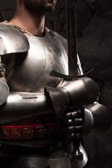 Closeup portrait of medieval knight in armor holding a sword