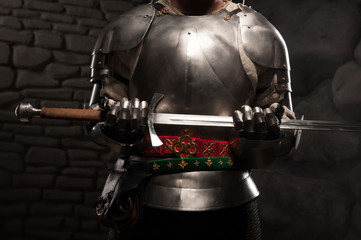 Closeup portrait of medieval knight in armor holding a sword