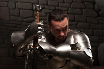 Fototapeta na wymiar Medieval knight kneeling with sword