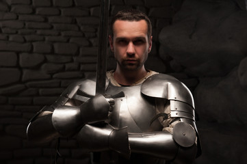 Medieval knight kneeling with sword