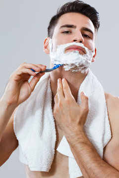 Handsome man shaving his beard
