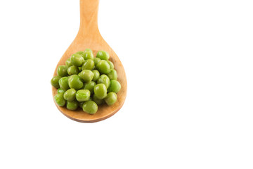 Green peas on wooden spoon over white background