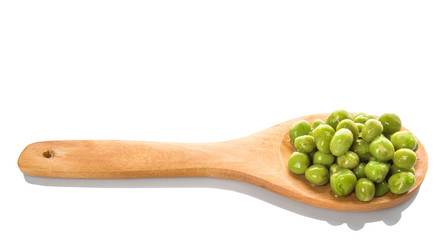 Green peas on wooden spoon over white background
