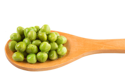 Green peas on wooden spoon over white background