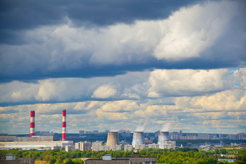 Fototapeta na wymiar Industrial district, fuming industrial chimney. Blue sky