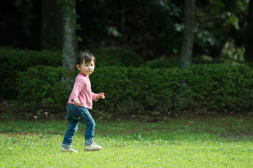 Little girl walking in the green grass