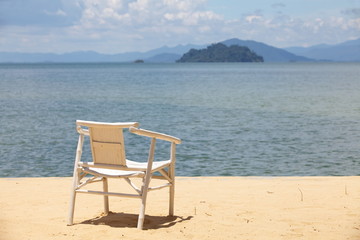 Fototapeta na wymiar chair on sand beach Concept for rest, relaxation