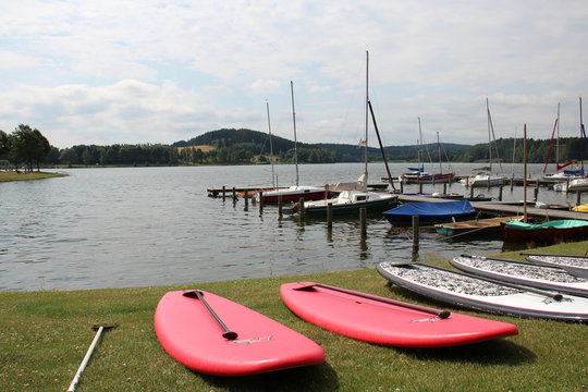 Stand-Up-Paddling (SUP) am Untreusee in Hof an der Saale, Anlegersteg mit Boote und roten SUPs an der K&uuml;ste