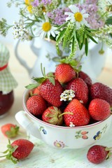 Fresh strawberries and a bouquet of wildflowers