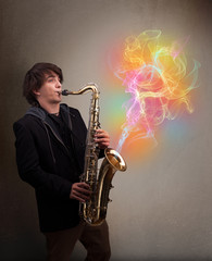 Naklejka na ściany i meble Attractive musician playing on saxophone with colorful abstract