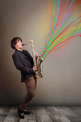 Attractive musician playing on saxophone while colorful abstract