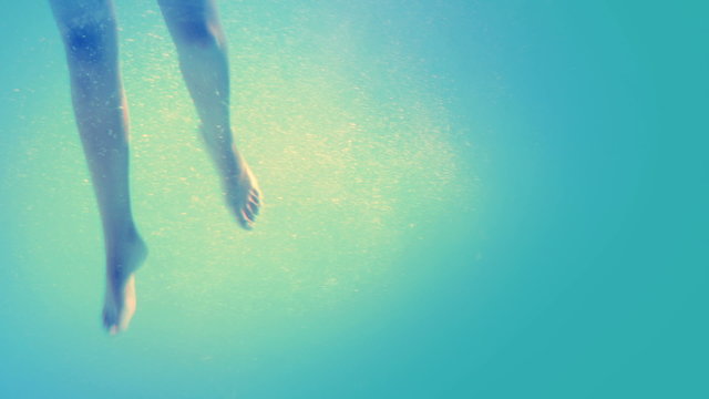 Brunette in bikini diving into swimming pool