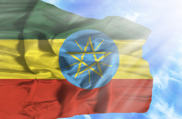 Ethiopia waving flag against blue sky with sunrays