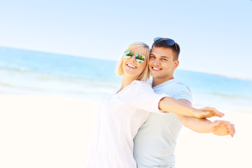 Happy couple hugging at the beach