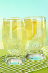 Delicious lemonade on table on light blue background