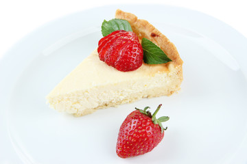 Slice of cheesecake with strawberry on plate, isolated on white