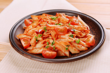 Pasta with tomato sauce on plate on table close-up