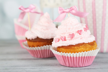 Tasty cup cakes with cream on grey wooden table