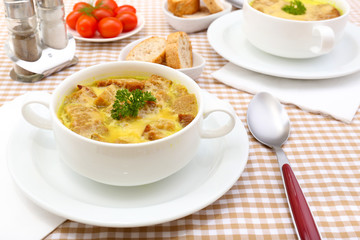 Tasty soup in saucepans on tablecloth, close up