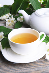 Cup of tea with jasmine on table close-up
