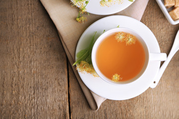 Tasty herbal tea with linden flowers on wooden table