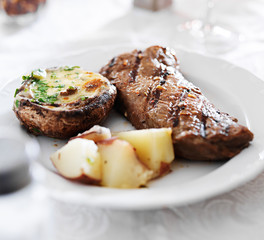 grilled strip steak with potatoes and stuffed mushroom