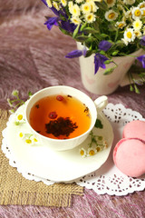 Cup of fresh herbal tea on table