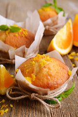Tasty cupcakes with orange on table close-up