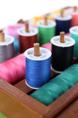 Colorful threads for needlework in wooden box close up