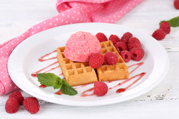 Tasty belgian waffles with ice cream on wooden table