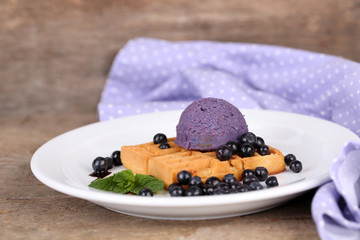 Tasty belgian waffles with ice cream on wooden table