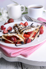 Delicious pancakes with berries on table close-up